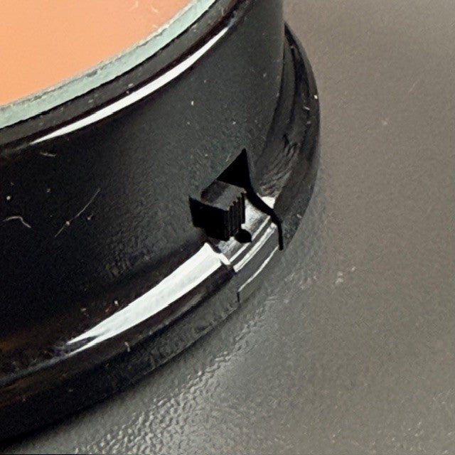 On/off button on a black round battery light base
