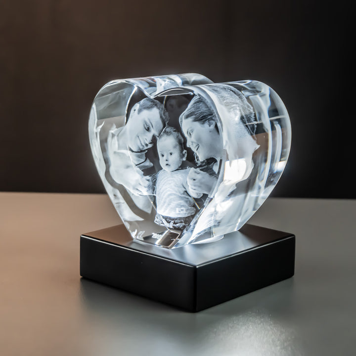 Glass heart with family seen from the side on a matte black luxury light base