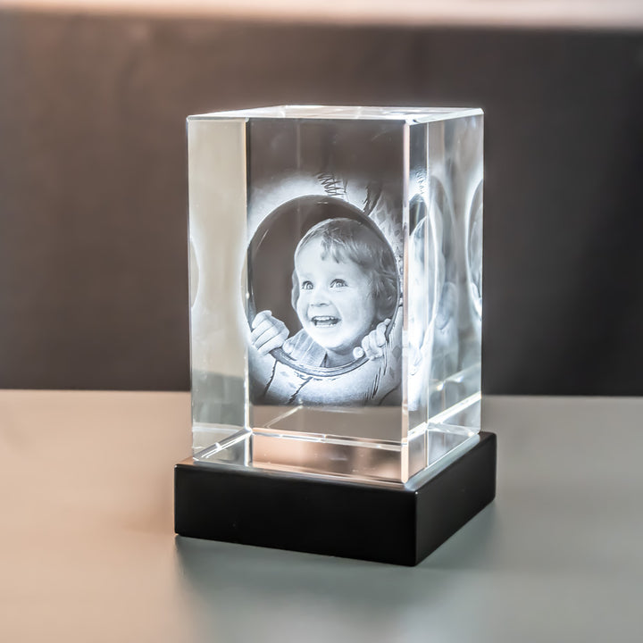 Glass block 8x8x12 cm with child seen at an angle on a matte black luxury light base