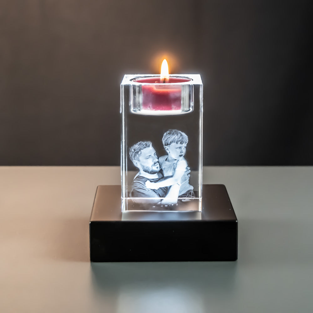 Crystal glass tea light holder with engraved father and son and lit candle on a luxury light base
