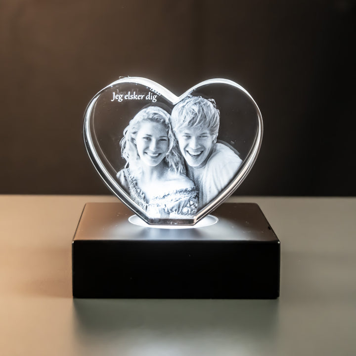 Upright glass heart with engraved couple and text on a luxury light base