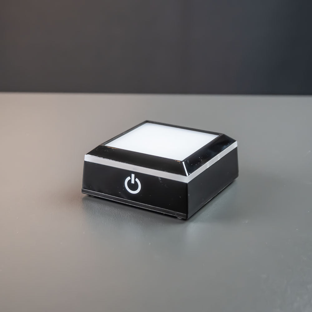Sort kvadratisk lysbase 7×7 cm med tændt hvidt lys