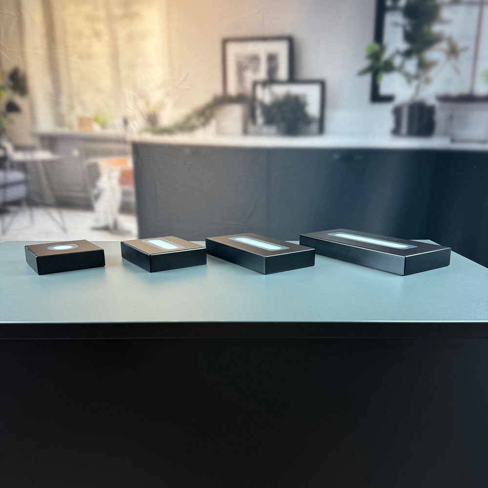 Four matte black luxury light bases in all sizes side by side
