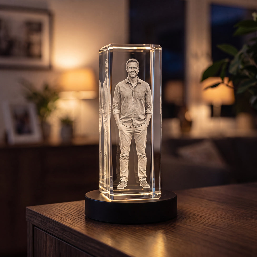 Høj glasblok med 3D-graveret stående mand på sort lysbase