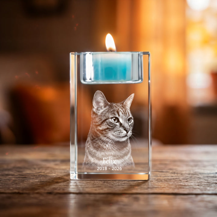 Crystal glass tea light holder with 3D laser-engraved cat, name and year and a lit blue tea light