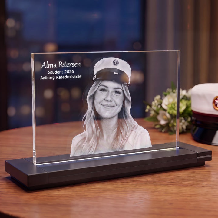 Crystal glass photo frame with 2D laser-engraved portrait of a new graduate and text, on a black stand