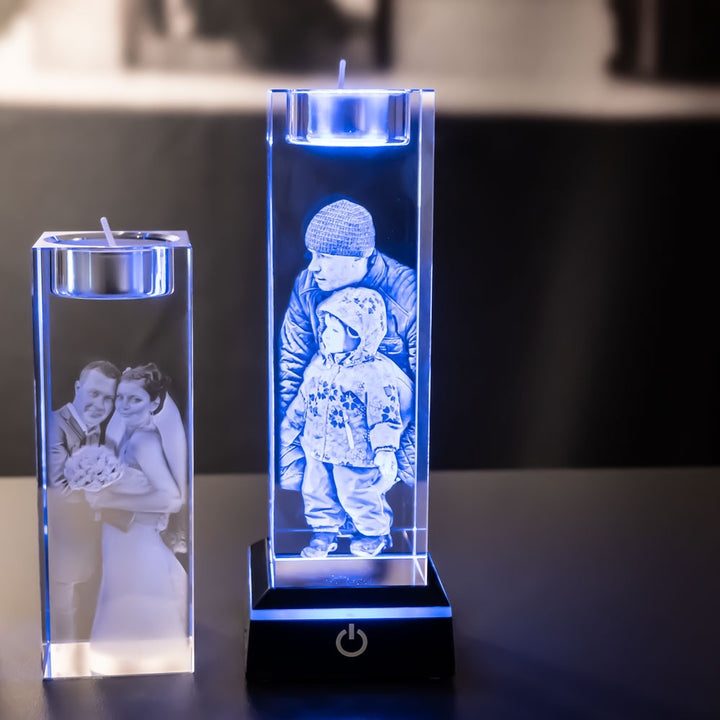 Two tea light holders with bride and groom and father and child, one lit blue by a light base