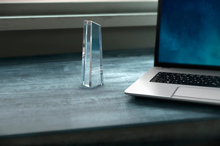 Tall crystal glass obelisk award on a desk