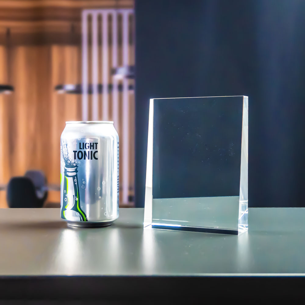 Prism award next to a soda can for size comparison, upright