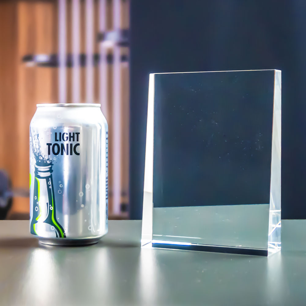 Prism award and soda can close up, showing the size