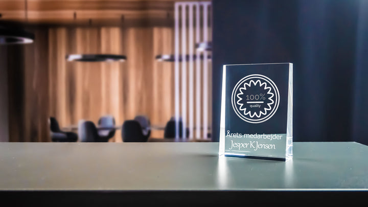 Prism award with 2D-engraved logo and text in an office setting