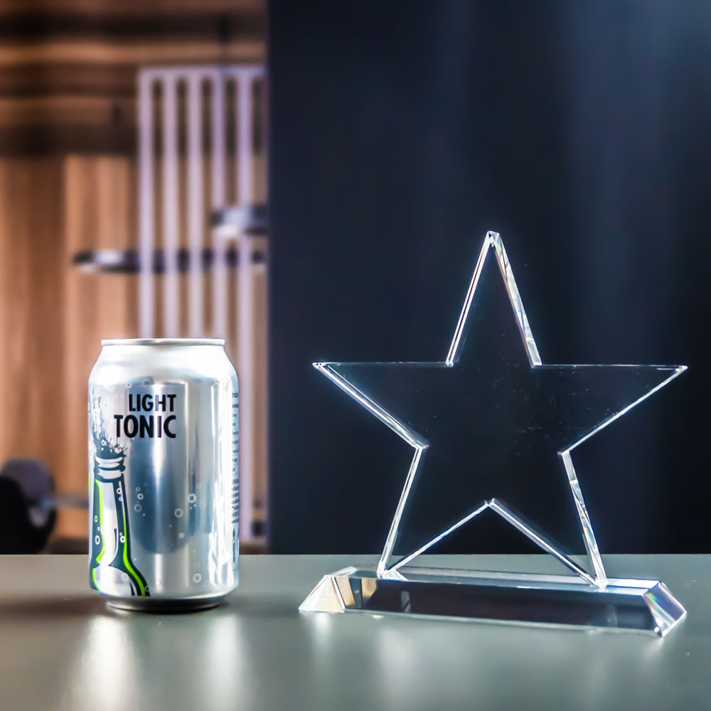 Crystal glass star award next to a can for size