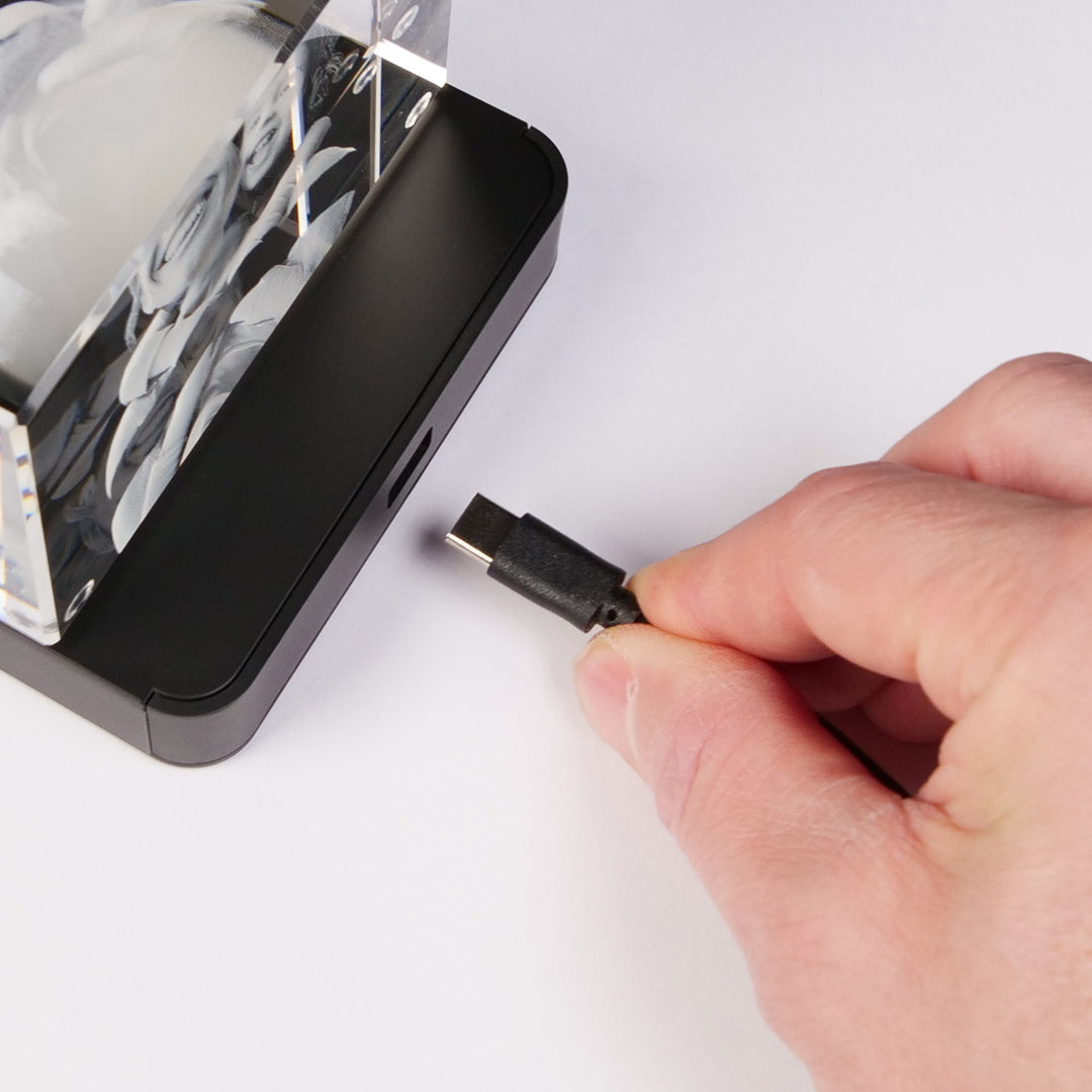 USB-C cable plugged into a multi light base under a glass block