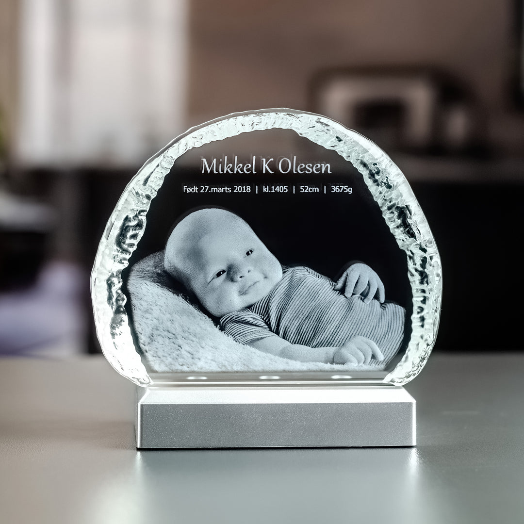 Small iceberg-shaped glass block with 3D-engraved newborn baby and name on a light base