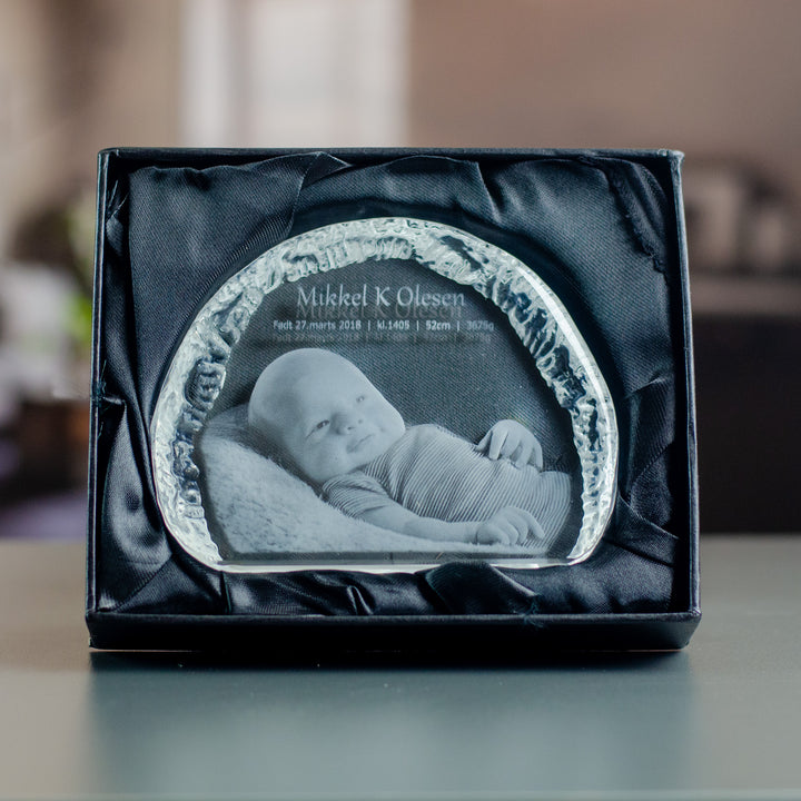 Small iceberg-shaped glass block with engraved baby in a black gift box