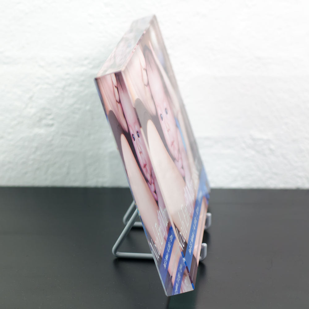 Print glass with colour print of mother and baby seen from the side on a metal stand