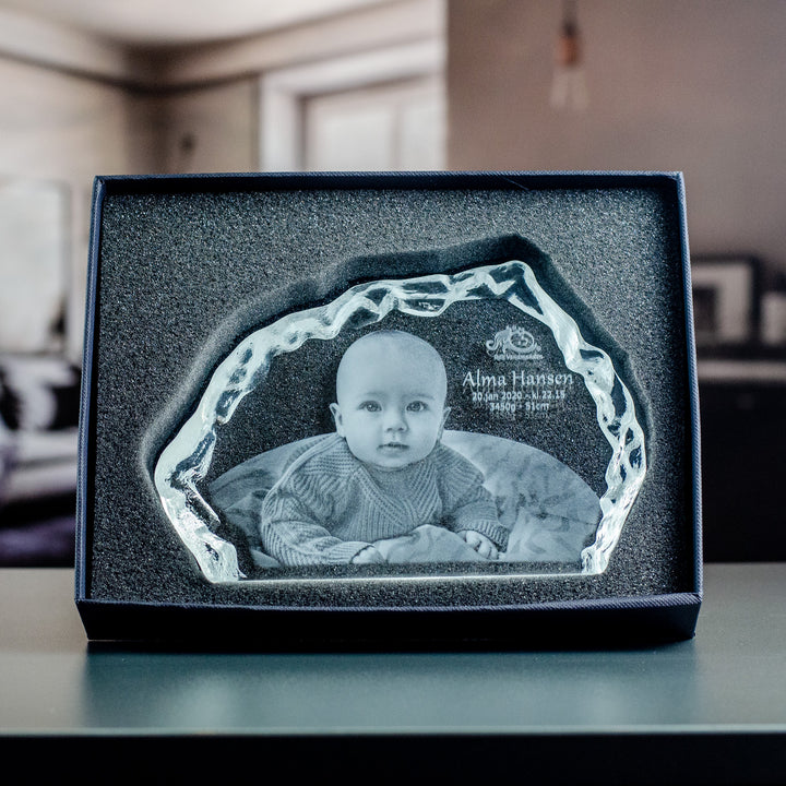 Iceberg-shaped glass block with engraved baby in a black gift box