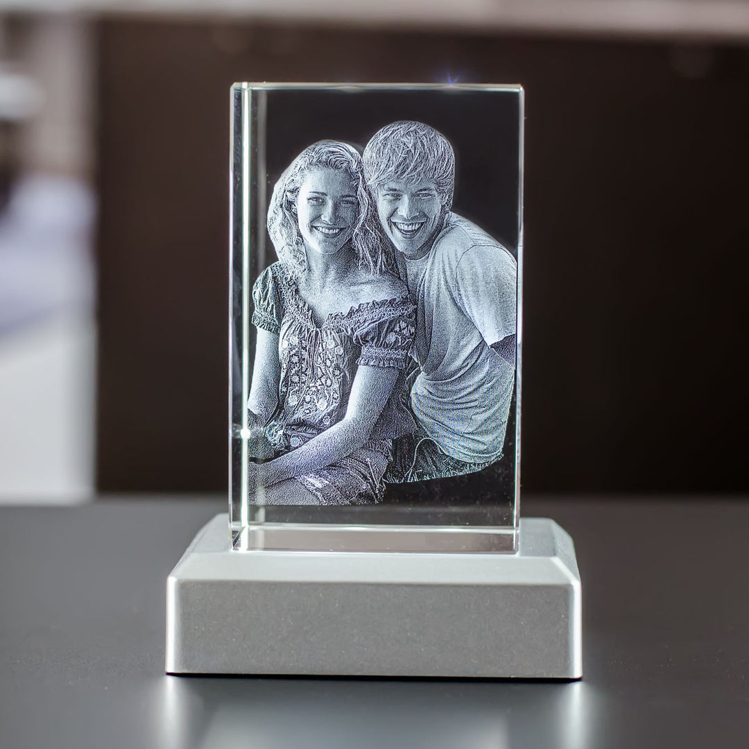 Upright rectangular glass block with engraved couple on a silver metal light base