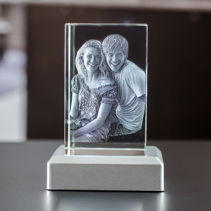 Upright rectangular glass block with engraved couple on a silver metal light base