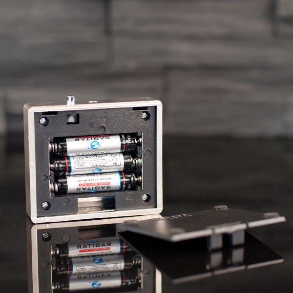 Open battery compartment with 3 AAA batteries in battery light base 6x6 cm