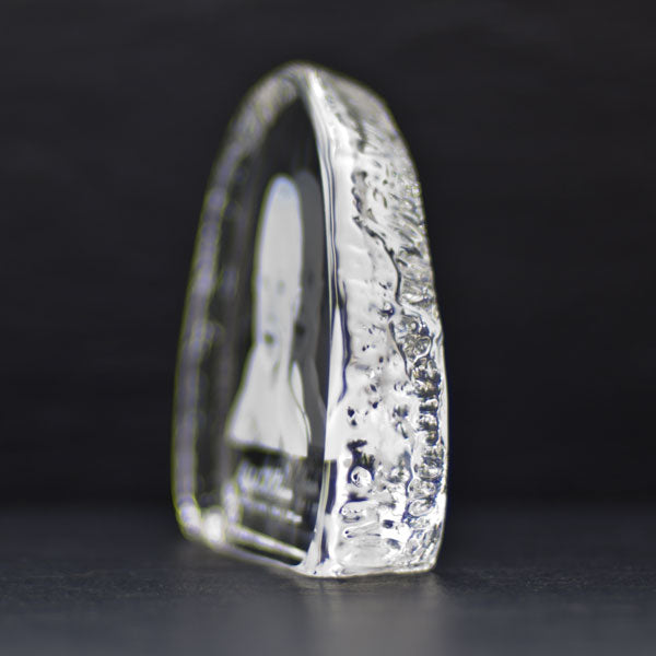 Small iceberg-shaped crystal glass block seen from the side