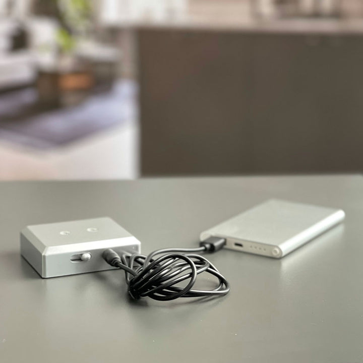 Power supply and two light-coloured metal battery light bases